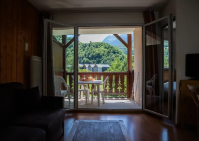 Séjour avec terrasse où le petit-déjeuner est servi et vue sur la montagne