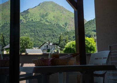 Séjour avec terrasse où le petit-déjeuner est servi et vue sur la montagne